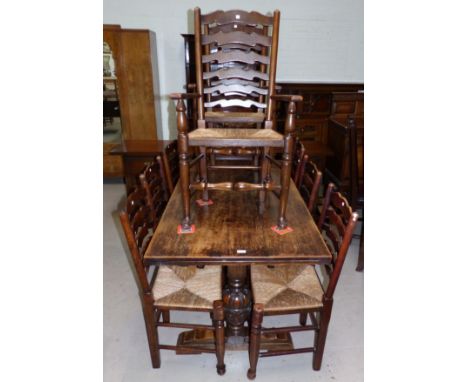 A period style matched dining suite comprising extending refectory table on carved bulbous legs, 8 (6 + 2) ladder back chairs