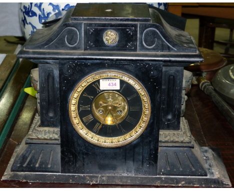 A 19th century French architectural mantel clock, black marble, with face mask mounts, exposed escapement and French striking