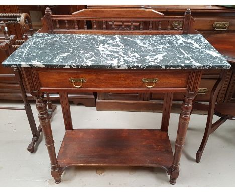 A 1920's oak washstand with marble top, shelf under, on turned legs