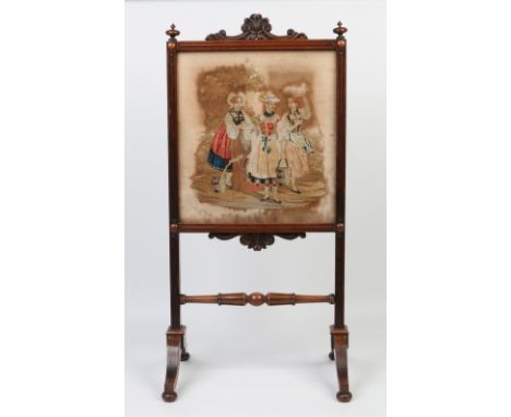 A Victorian carved mahogany firescreen. Set with a needlework panel depicting three milkmaids and raised on scrolling support