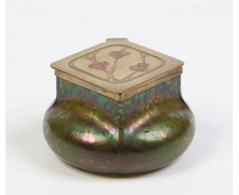 An Art Nouveau Loetz style iridescent glass inkwell with brass hinged cover engraved with stylized trees and having pot liner