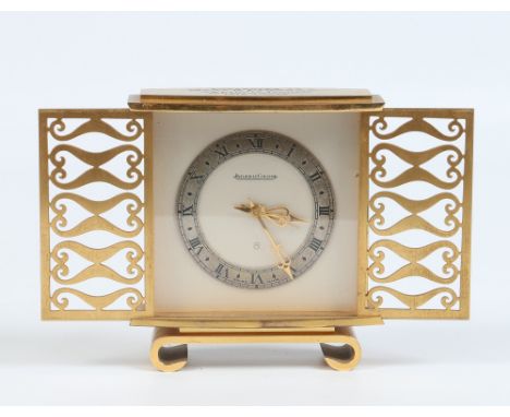 A Jaeger le Coultre brass cased mantel clock c1960 with silvered dial and chapter ring with Roman numeral markers. With slidi
