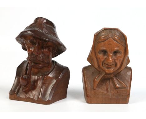 Two Black Forrest carved wooden small busts. One the portrait of a man wearing a Bavarian type hat and smoking a pipe the oth