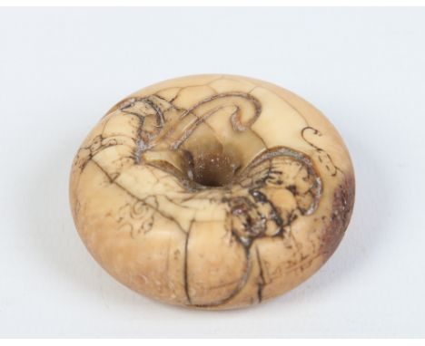 A Japanese carved ivory ring shaped toggle. Decorated in relief with a figure, 4.75cm diameter. Condition Report. To be used 