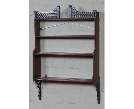 A nineteenth century mahogany four tier waterfall wall shelf. With pierced trellis gallery and openwork scrolling corbel supp
