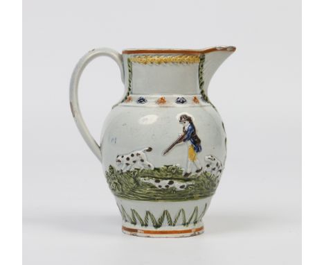 An early nineteenth century prattware jug. With applied mouldings depicting fox hunting scenes and decorated with coloured en