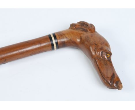 A walking stick with ebony and ivory collar and novelty handle carved in the form of a greyhounds head, 90cm. Condition Repor