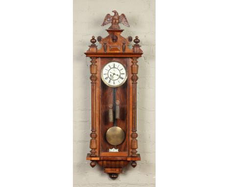A nineteenth century walnut cased eight day twin weight Vienna wall clock by Gustav Becker. With eagle pediment and ornamente