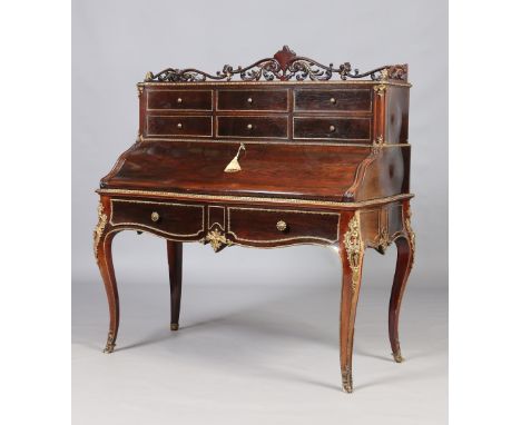A fine nineteenth century French rosewood bombe shaped desk. With carved openwork scrolling gallery, ormolu mounts and raised
