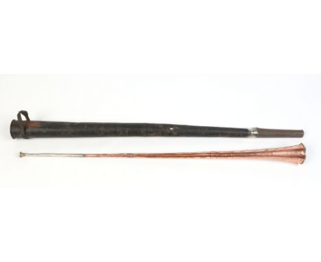 A copper hunting horn in tin case, horn 103cm. Condition Report. To be used as a guide only. Heavily dented. Case tired.