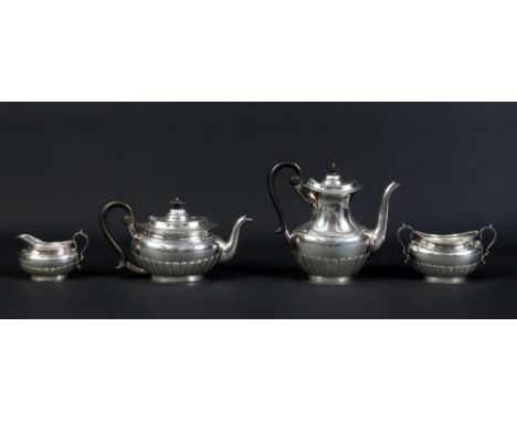 An Edwardian silver four part tea and coffee service by the Goldsmith's and Silversmith's Company. With double scrolling hand