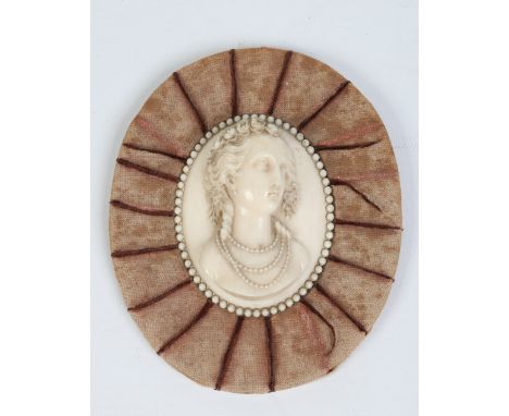 A nineteenth century European carved ivory portrait miniature depicting a young lady wearing a rose garland and pearl necklac