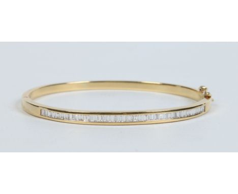 A ladies 18 carat gold bangle set with thirty eight baguette cut diamonds. 19.1 grams, 6.25cm wide. Condition Report. To be u