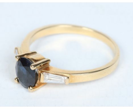 An Art Deco style 18 carat gold ring set with an ovoid sapphire flanked by a pair of trapeze cut diamonds. Ring size N. Condi