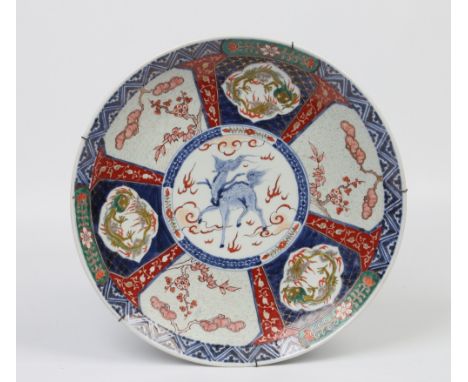 A Japanese Meiji period Imari charger. Decorated to the centre with a kirin and panels of dragons and prunus blossom to the b