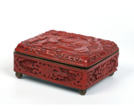 A nineteenth century Chinese cinnabar lacquer box with hinged cover. Decorated in relief with figures under the shade of a pi