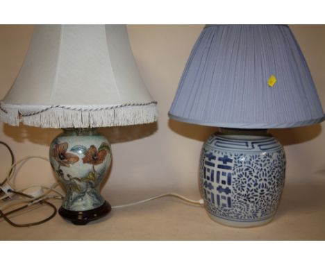 AN ORIENTAL STYLE BLUE AND WHITE CERAMIC TABLE LAMP TOGETHER WITH A FLORAL EXAMPLE