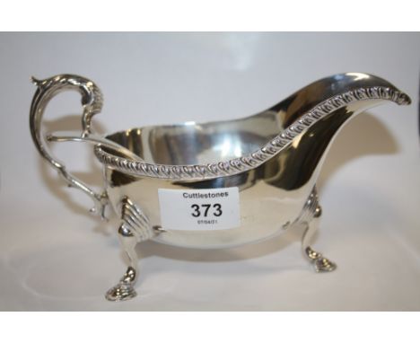 A HALLMARKED SILVER SAUCE BOAT TOGETHER WITH A PLATED LADLE