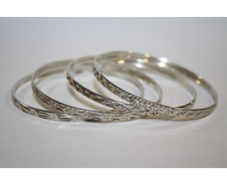 A SET OF FOUR VINTAGE SILVER ENGRAVED BANGLES - APPROX 32G