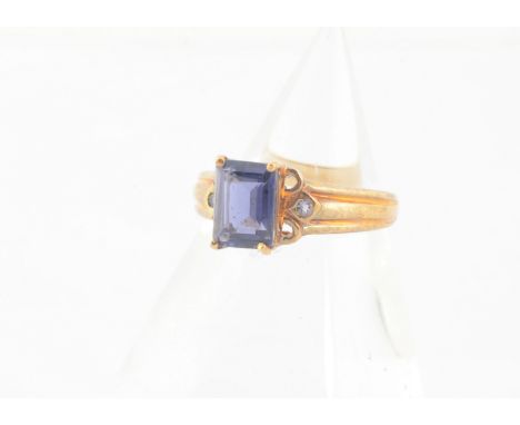 A 9ct gold iolite dress ring, the step cut in claw setting with scroll shoulders and tapered shank, ring size N, 2.7g, with b