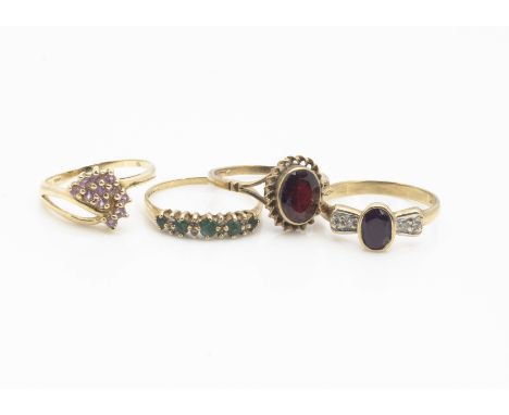 A ruby and diamond dress ring, ring size R, an emerald and cubic zirconia ring, ring size P, a garnet ring, ring size P and a