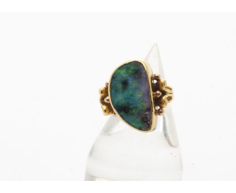 A continental black opal and yellow metal dress ring, the large oval shaped polished opal within a yellow metal mount with sc