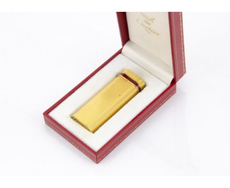 A Must De Cartier gilt cigarette lighter, with red enamel band to upper, in box 