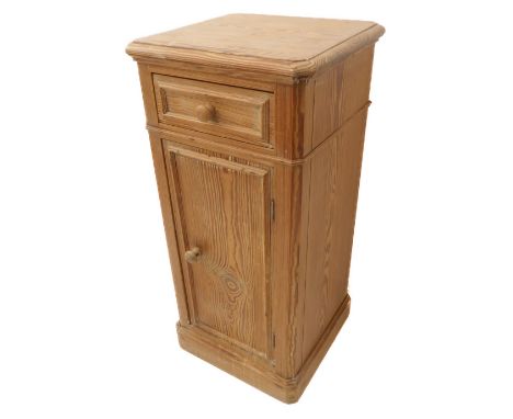 An early 20th century pitch pine cupboard: single drawer and panelled cupboard door below, on plinth base (38.5 cm wide)