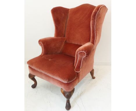 A large and comfortable early 18th century style (later) wing-back armchair: raised on carved walnut cabriole front supports 