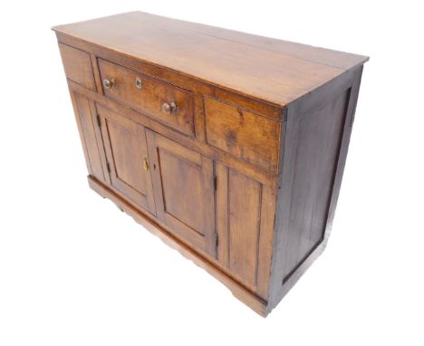 A 19th century oak dresser base of small proportions: slightly overhanging top above single drawer and two panelled doors bel