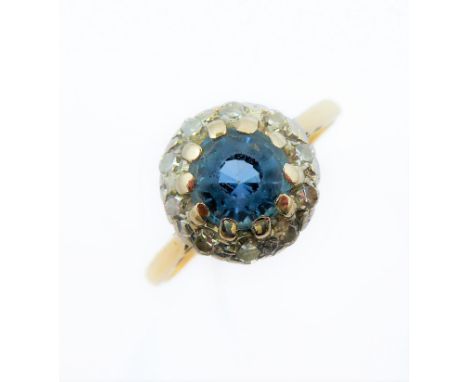 A blue topaz/aquamarine and diamond-set cluster ring: the circular mixed-cut blue topaz/aquamarine (untested) within a surrou