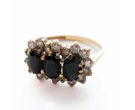 A 9-carat gold ring set with three black stones surrounded by white stones, ring size J/K&nbsp; (boxed)