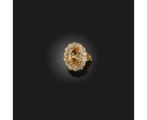 A topaz and diamond ring, of cluster design, claw-set with an oval step-cut yellow topaz weighing approximately 3.50 carats, 