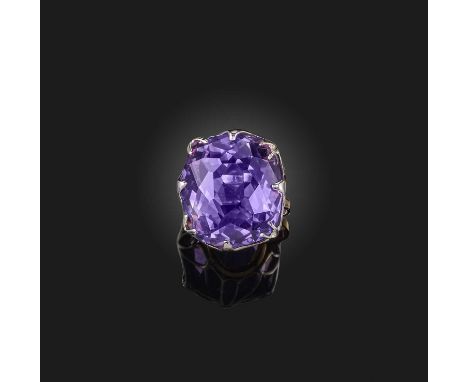 An amethyst solitaire ring, the large cushion-shaped amethyst claw-set in platinum and gold, size N