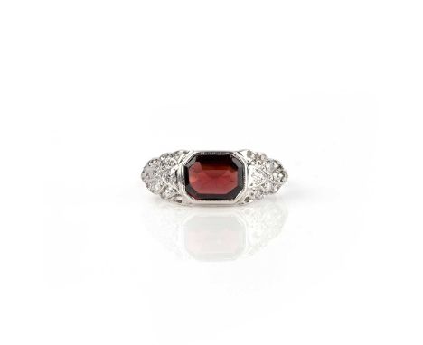 A garnet and diamond ring, set with a step-cut garnet, to shoulders of foliate design set with single-cut and rose-cut diamon