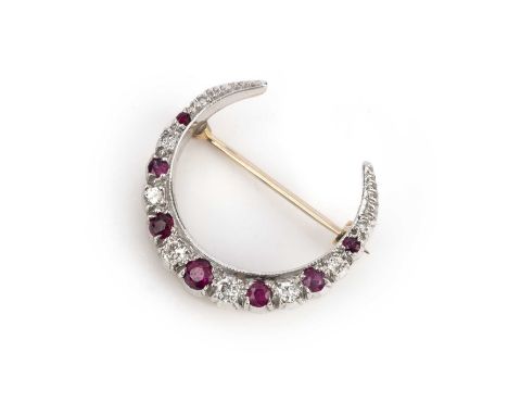 A ruby and diamond brooch, designed as a crescent moon, set with circular-cut rubies and brilliant-cut diamonds in alternatio