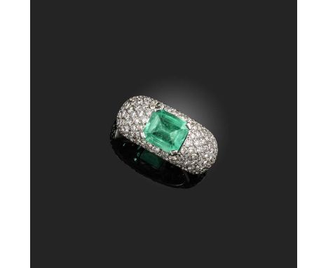 An emerald and diamond ring, centring on a step-cut emerald weighing approximately 2.00 carats, to a bombé mount pavé-set wit