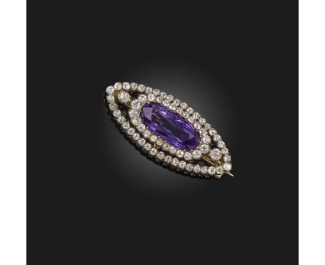 An amethyst and diamond brooch, circa 1900, of navette outline, set with an oval amethyst, bordered with circular-cut diamond