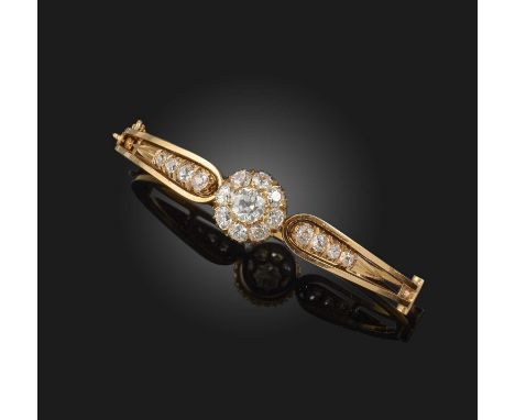 A late Victorian diamond bangle, set with a central cluster of circular-cut diamonds within diamond-set yellow gold shoulders