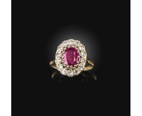 A ruby and diamond ring, of cluster design, set with an oval ruby, within a border of circular-cut diamonds, mounted in gold,