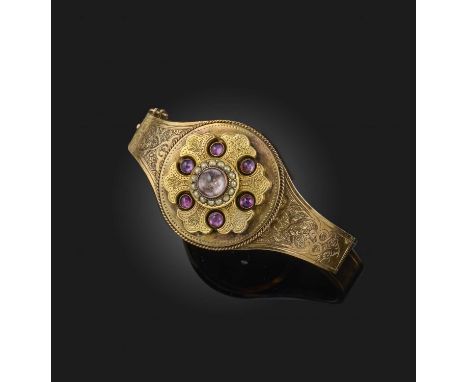 A Victorian gold, amethyst and seed pearl bangle, late 19th century, the hinged bangle centring on a roundel set with cabocho