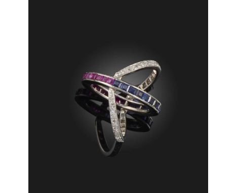 A sapphire, ruby and diamond ring, of 'day and night' design, composed of a central band, one side set with of calibré-cut ru