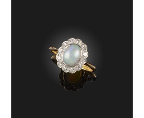 An opal and diamond ring, first half 20th century, of cluster design, set with a cabochon opal within a border of single-cut 