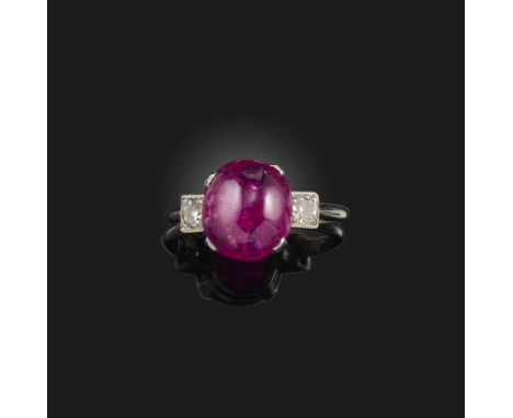 A cabochon ruby and diamond ring, the ruby flanked with small circular-cut diamonds in platinum, size L (shank split)Accompan