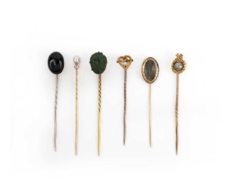 A collection of six stick pins, late 19th/early 20th century, comprising stick pins capped with: an onyx cabochon; a pearl an