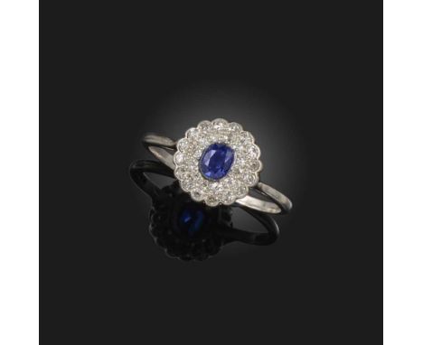 A synthetic sapphire and diamond ring, early 20th century, of cluster design, set with a cushion-shaped synthetic sapphire wi