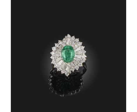 Larry, an emerald and diamond ring, set with an oval emerald, within an asymmetrical mount of scroll design, set with tapered