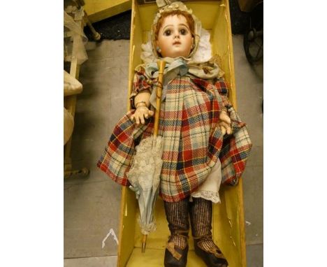 A Tete Jumeau bebe doll with fixed brown eyes, brown feathered brows, closed mouth, auburn mohair wig on cork pate, pierced e