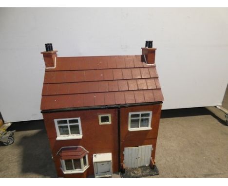 A 20th Century wooden dolls house with red brick facade and red brick facade roof tiles, with bay window to first level and d