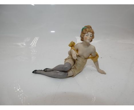 A bisque reclining bathing beauty, with turned head to the right, with blue painted eyes, green comb in hair, with legs outst